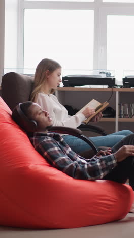 los estudiantes aprenden material con el tutor en la biblioteca. la mujer lleva a cabo pruebas comparando la lectura de libros y la escucha de audiolibros en la universidad. métodos de estudio