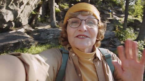 elderly woman chatting on web call during hike