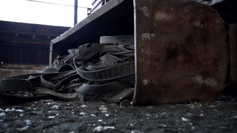 Old-rusty-iron-cole-wagon-filled-with-straps-lies-at-the-ground-of-abandoned-grunge-eerie-factory