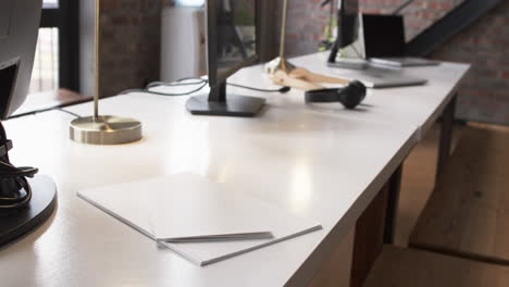 a modern business office desk is equipped with a computer, lamp, and headphones, with copy space