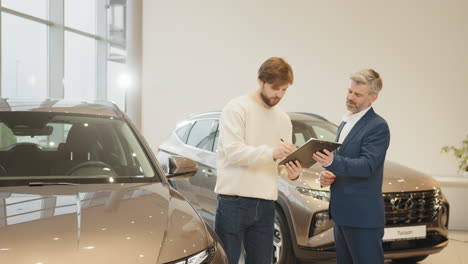 car dealership salesman discussing car purchase with customer