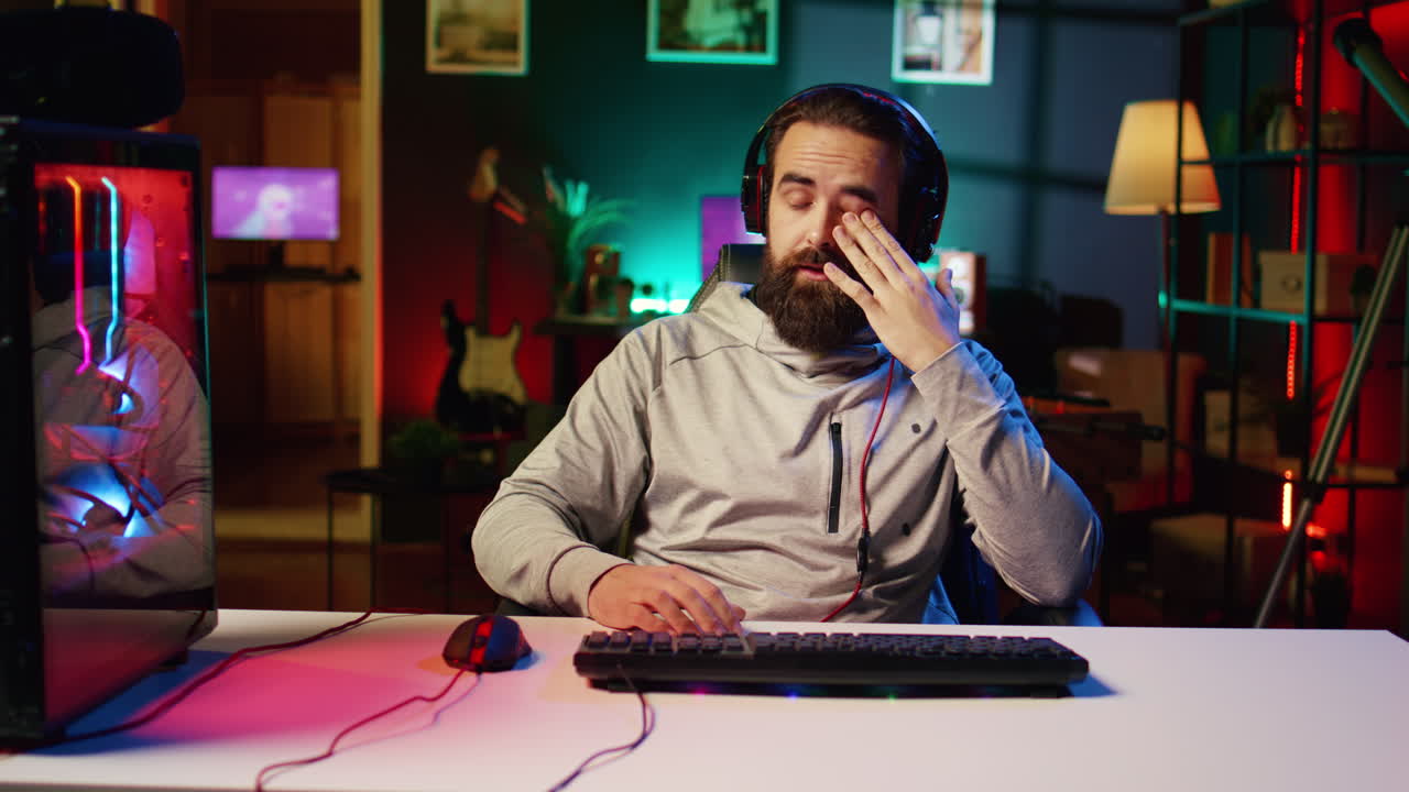 Player punching desk after being defeated by enemy in videogame internet tournament