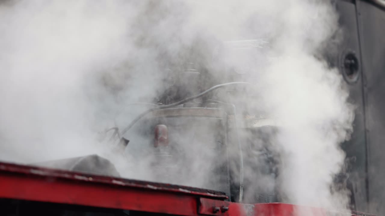 una locomotora de tren de vapor de época. un tren de locomotora con fugas de humo, el vapor se encendió por detrás.
