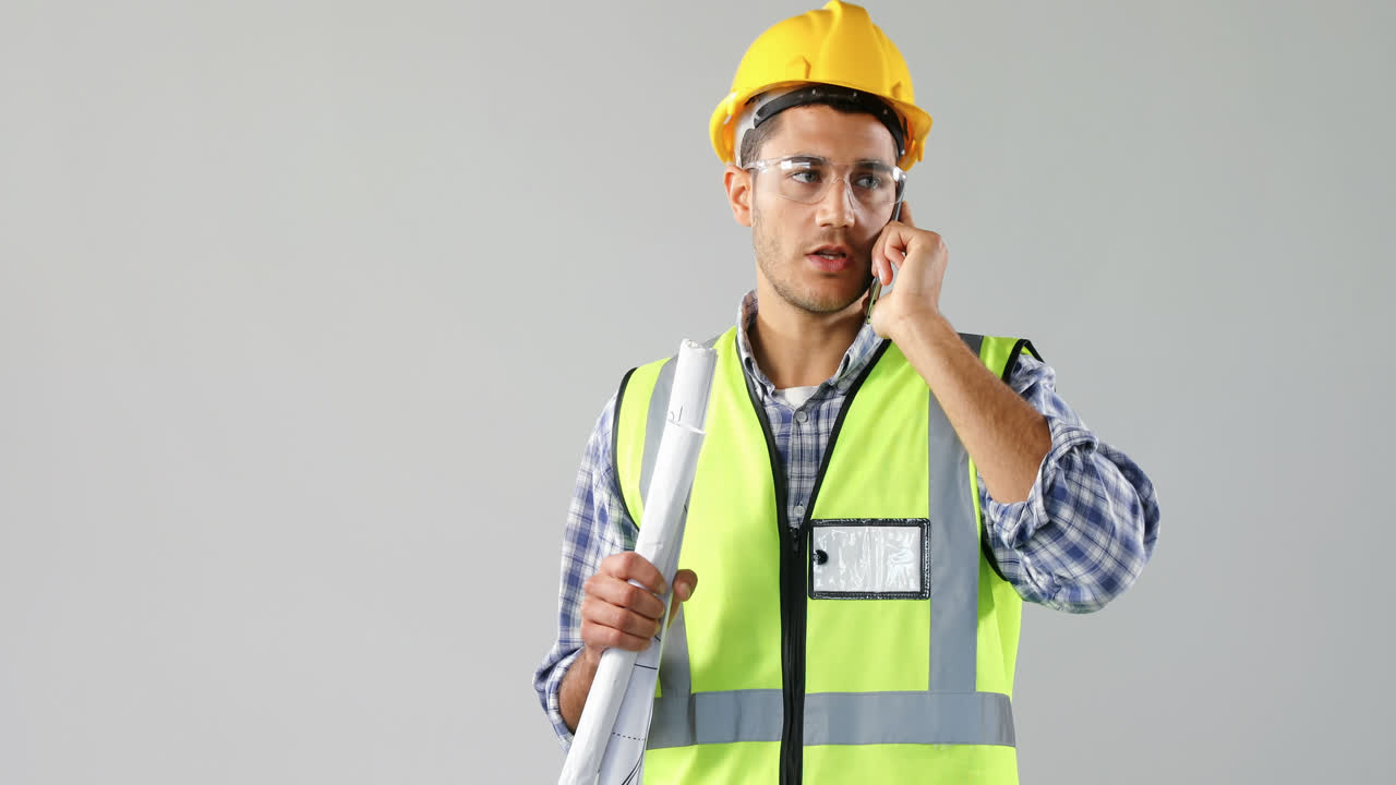 arquitecto masculino sosteniendo el plan y hablando en teléfono móvil 4k 4k