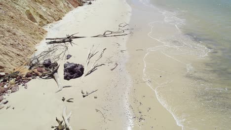 turista mirando hacia la cámara de un dron mientras camina por la playa del arco iris en cooloola, queensland