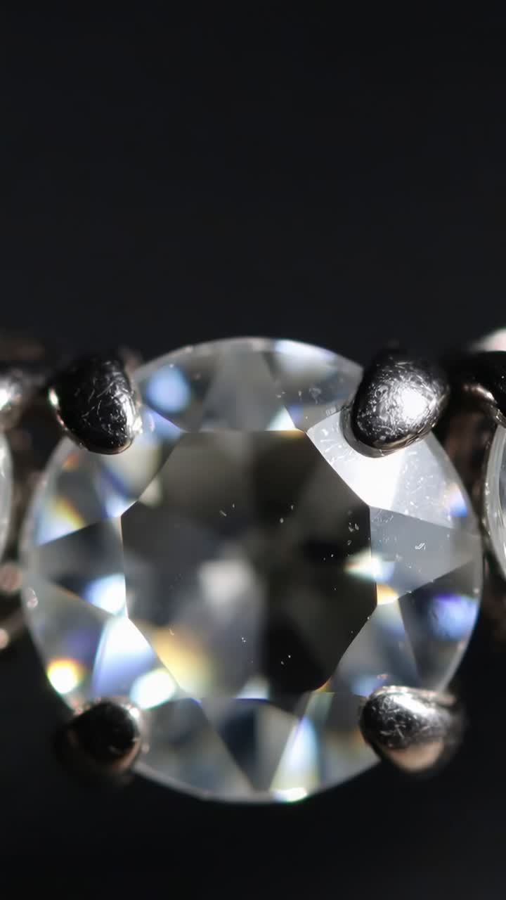 Vertical video: Camera shifting focus, lighting revealing gem, highlighting prongs, dust and star