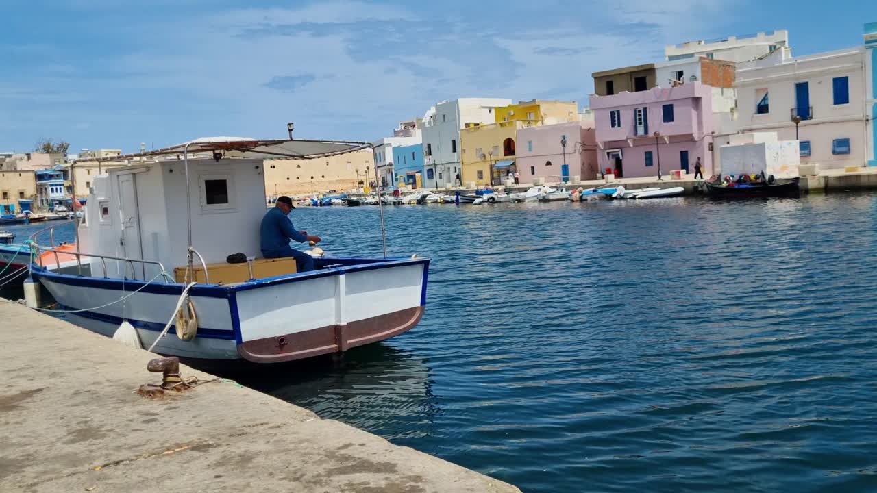 Fisherman on a boat in a colorful harbor in Tunisia