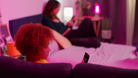 young women relaxing in bedroom at night