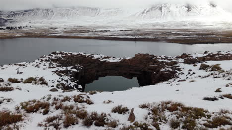 snow-covered stone bridge crosses caviahue lake with mountain backdrop on a peaceful winter day