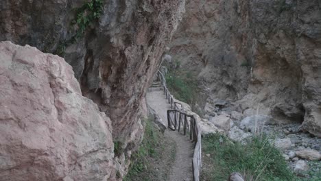 mountain-path-carved-into-the-rocky-mountain-with-brown-fences-delimiting-the-route