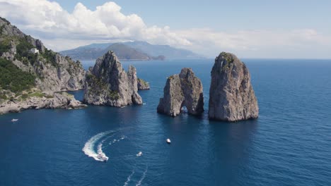 luxury yacht boats by faraglioni rocks off island of capri, italy, aerial