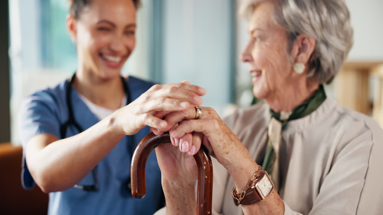 Nurse assisting elderly woman with cane