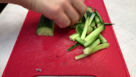 Close up of a woman's hands julienning cucumbers