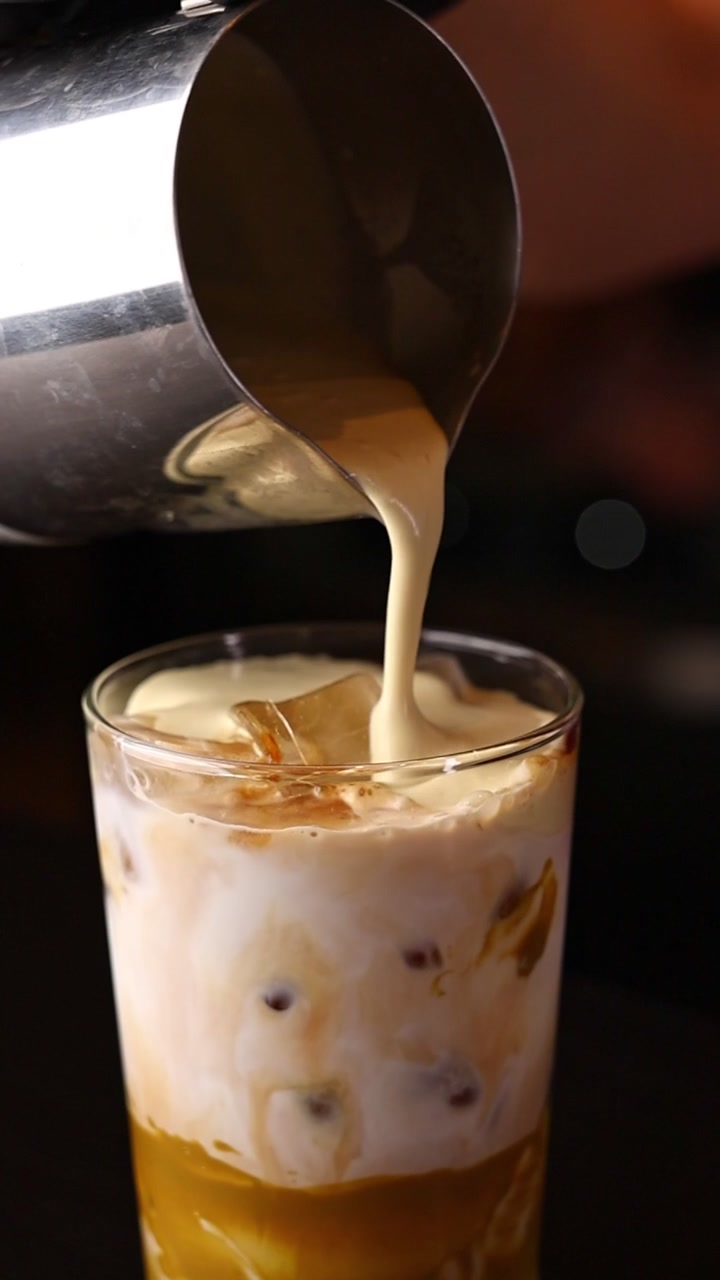Barista che versa latte cremoso nel caffè freddo