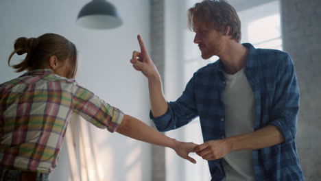 una familia alegre bailando en casa, una pareja feliz regocijándose juntos en su nueva casa.