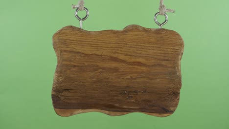 panorama of a wooden sign hanging on the ropes. isolated on a green screen