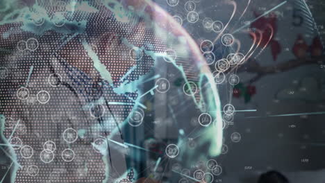 man tutoring boy in technology workshop while projecting holographic globe with network icons