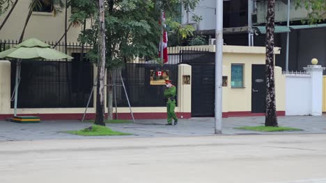 soldier walking past building in hanoi, vietnam