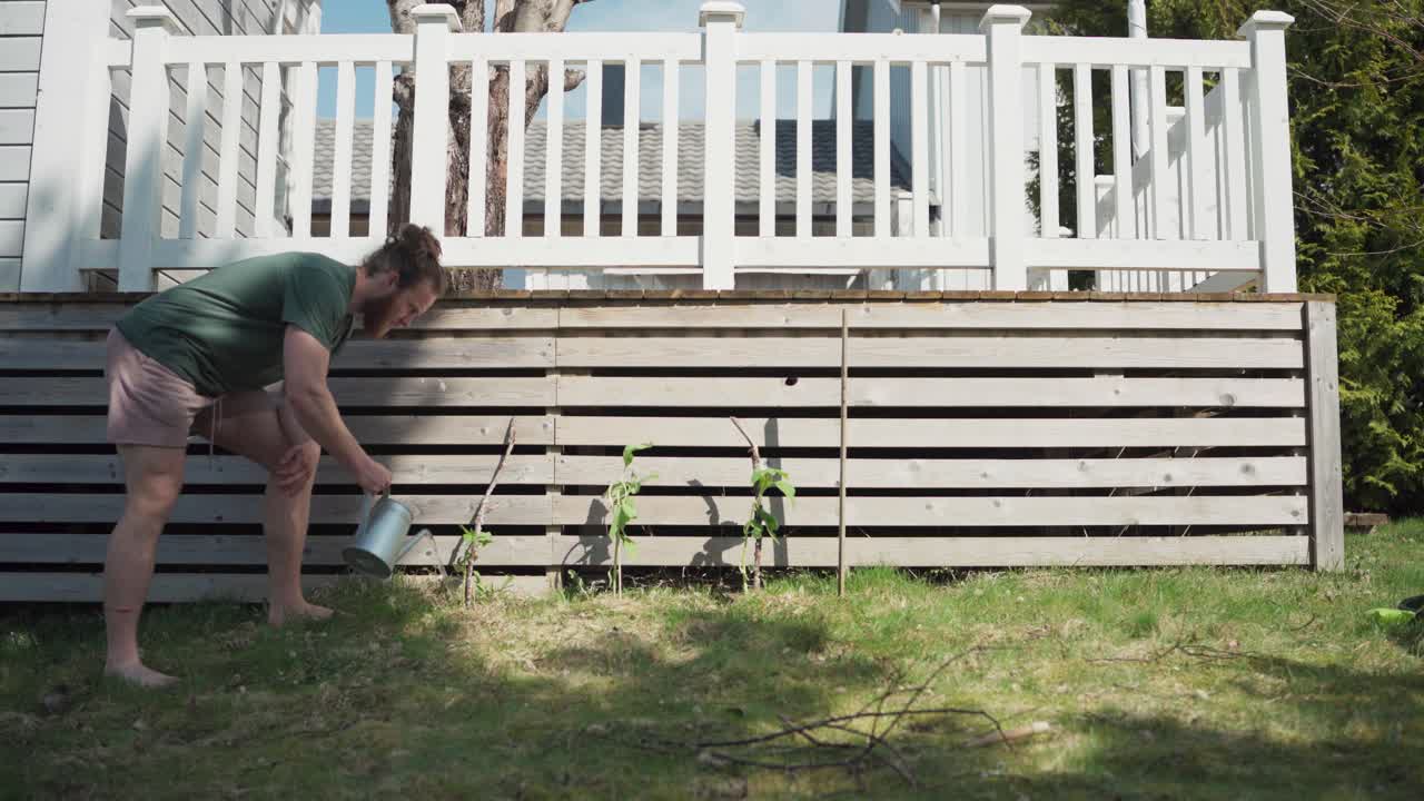 En person vander planter i vækst i sin baghave