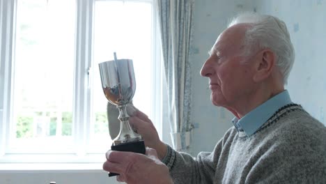 senior caucasian man cleaning his trophy