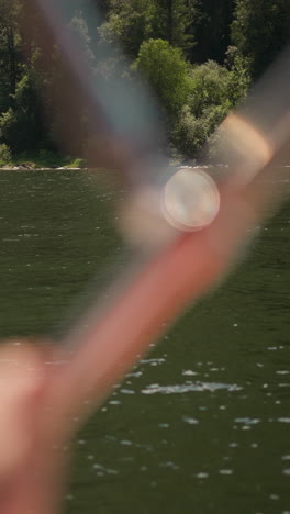 picturesque riverbank with growing old forest on sunny day view from tourist yacht. deep wood on sloped lake bank and blurry sailing motorboat