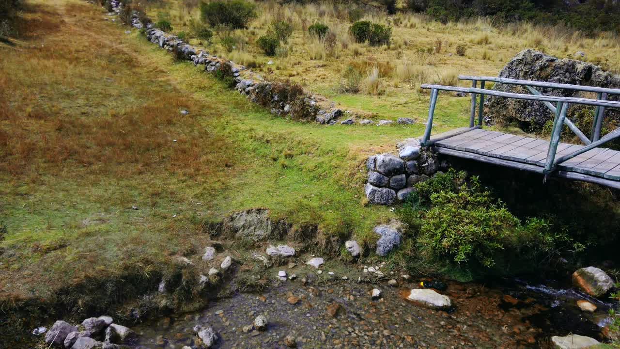 Scenic wooden bridge over a stream connecting Inkilltambo and Qhapaq Ñan and Rumiwasi ruins, Cusco.