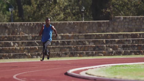 disabled mixed race man with prosthetic legs running on race track