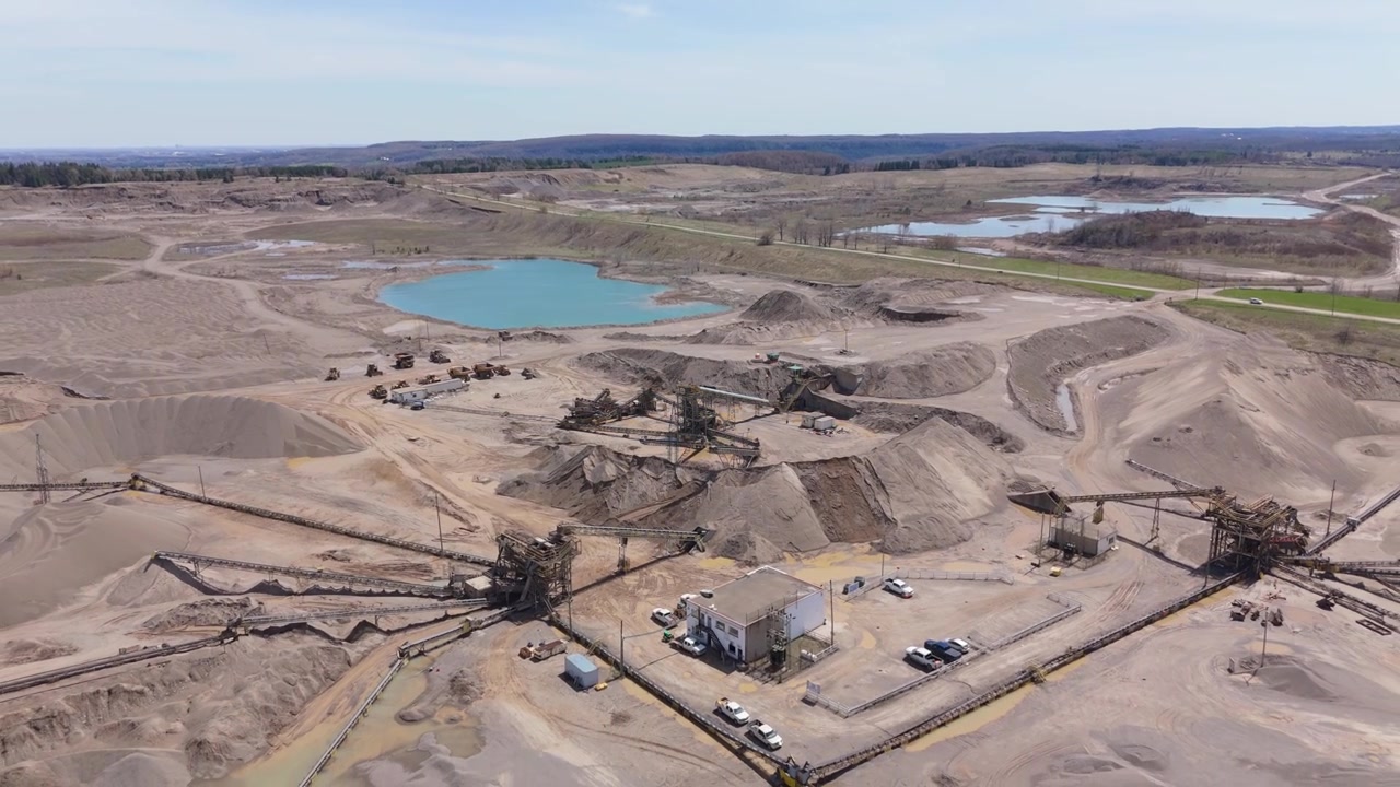 Large Heavy Equipment Operating At An Active Industrial Quarry Near Caledon Village, Ontario, Canada. Aerial Pullback Shot