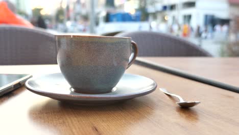 a cup of coffee on a cafe table outdoors