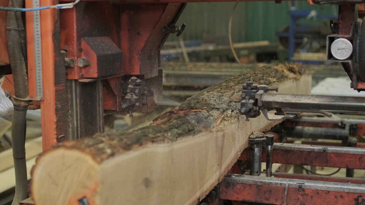 Industriell sagbruksmaskin kutter en stor tømmerstokk