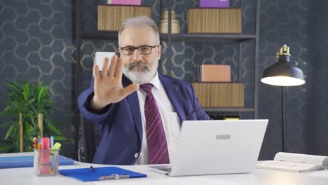 businessman saying stop to camera.