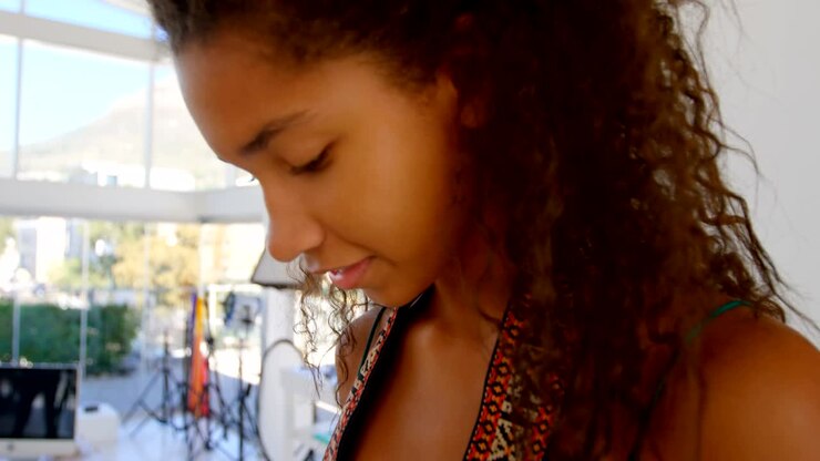 Modella che tiene la fotocamera in uno studio fotografico 4k