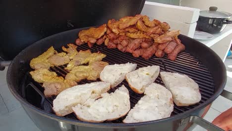 man with inox clamps turning round marinated chicken breasts-1