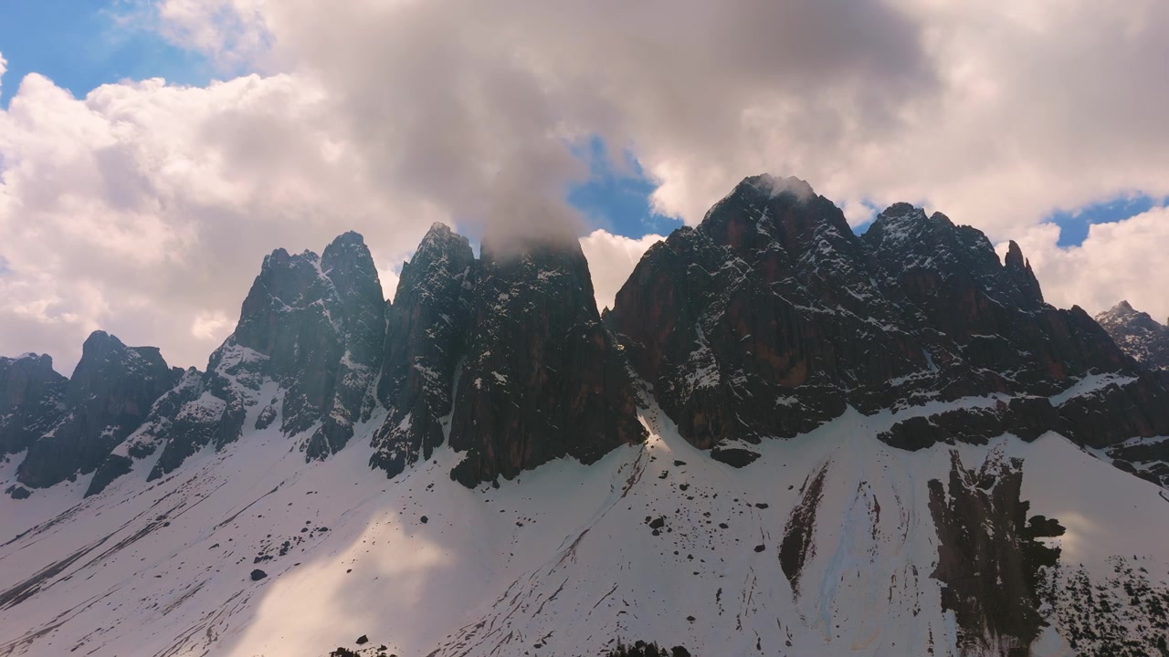 Imponenti cime delle Odle nel Parco Naturale Puez-Geisler, Dolomiti, con neve. Vista aerea dal basso.