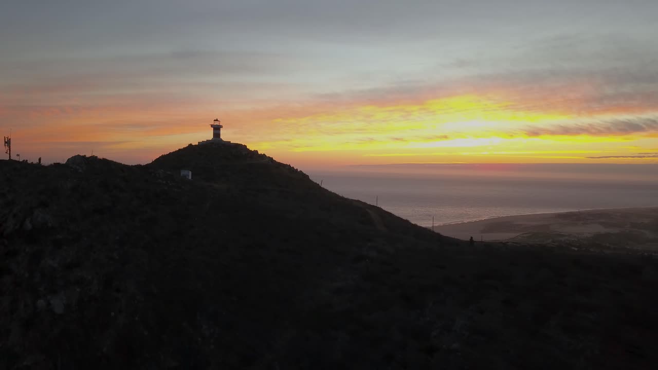 Beacon on top of hill overlooking Cabo Falso sea and beach. Sunset aerial view. Cabo San Lucas, Baja California Sur, Mexico