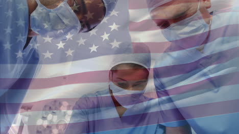 composite video of waving us flag over team of surgeons performing operation at hospital