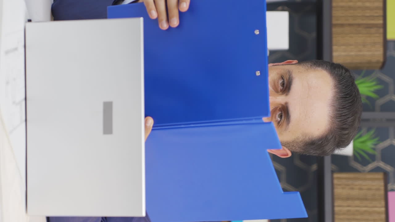 el video vertical del hombre de negocios positivo cierra los archivos de papeleo.