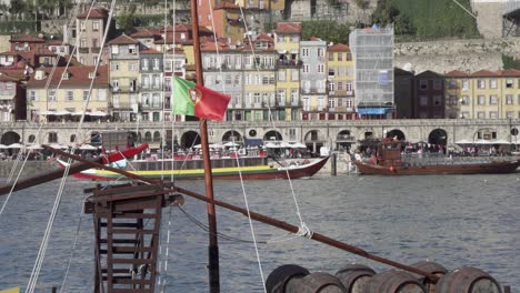 the iconic rabelo boats which are the traditional port wine transports with portugal flag