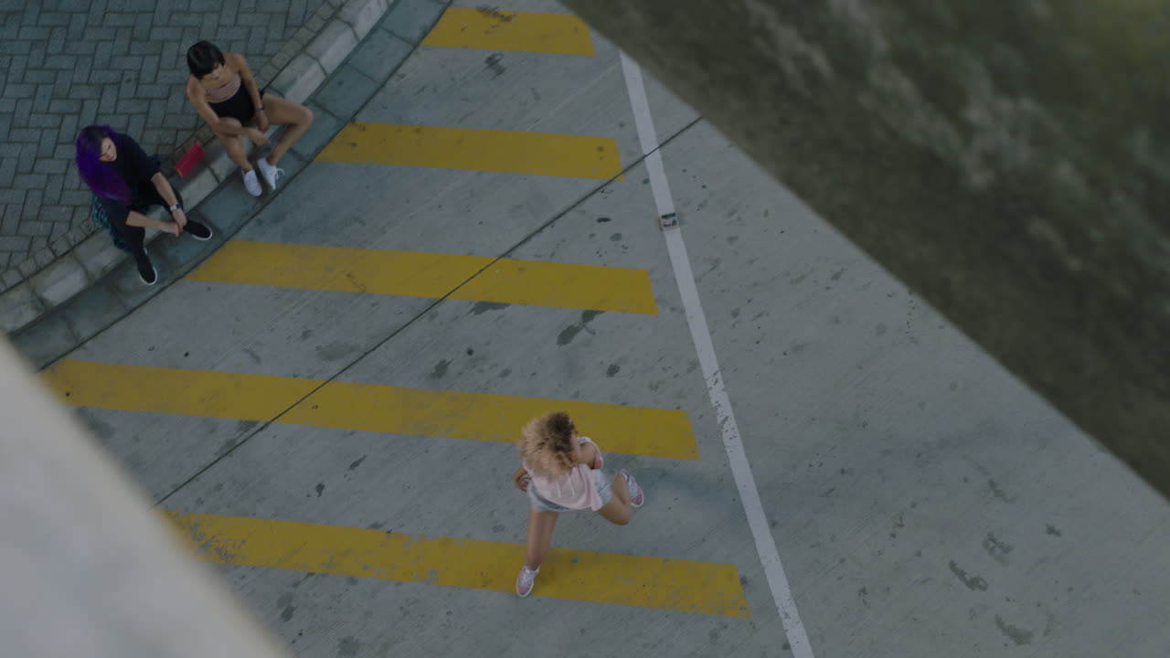 bailarina joven bailarina de calle con afro realizando movimientos contemporáneos amigos viendo disfrutar del baile de estilo libre urbano en la vista superior de la ciudad