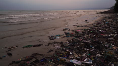 Pile Of Garbage Washed Ashore On The Beach After The Storm In The Evening