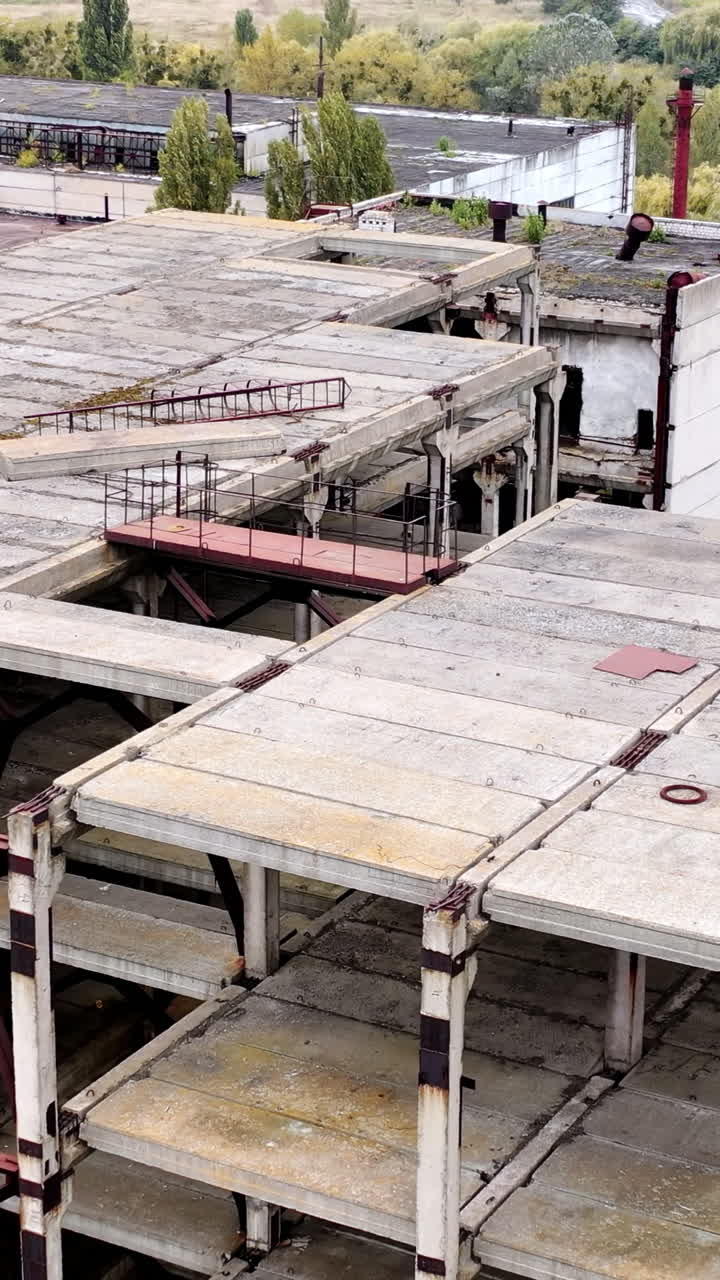 Ruined buildings. Industrial constructions without windows on abandoned plant. Old manufacture. Circling view.. Vertical video