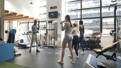 group fitness training with dumbbells in gym
