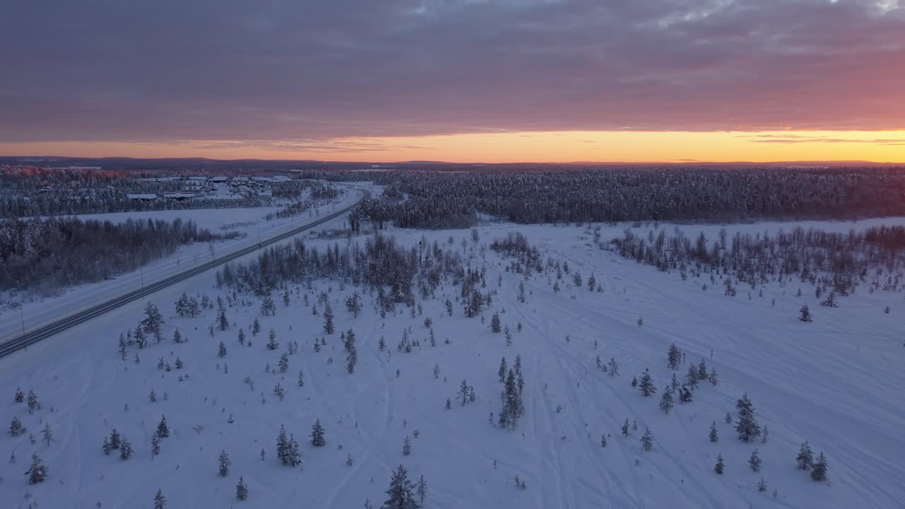To snøscootere i snørikt arktisk landskap ved solnedgang - Luftsporing