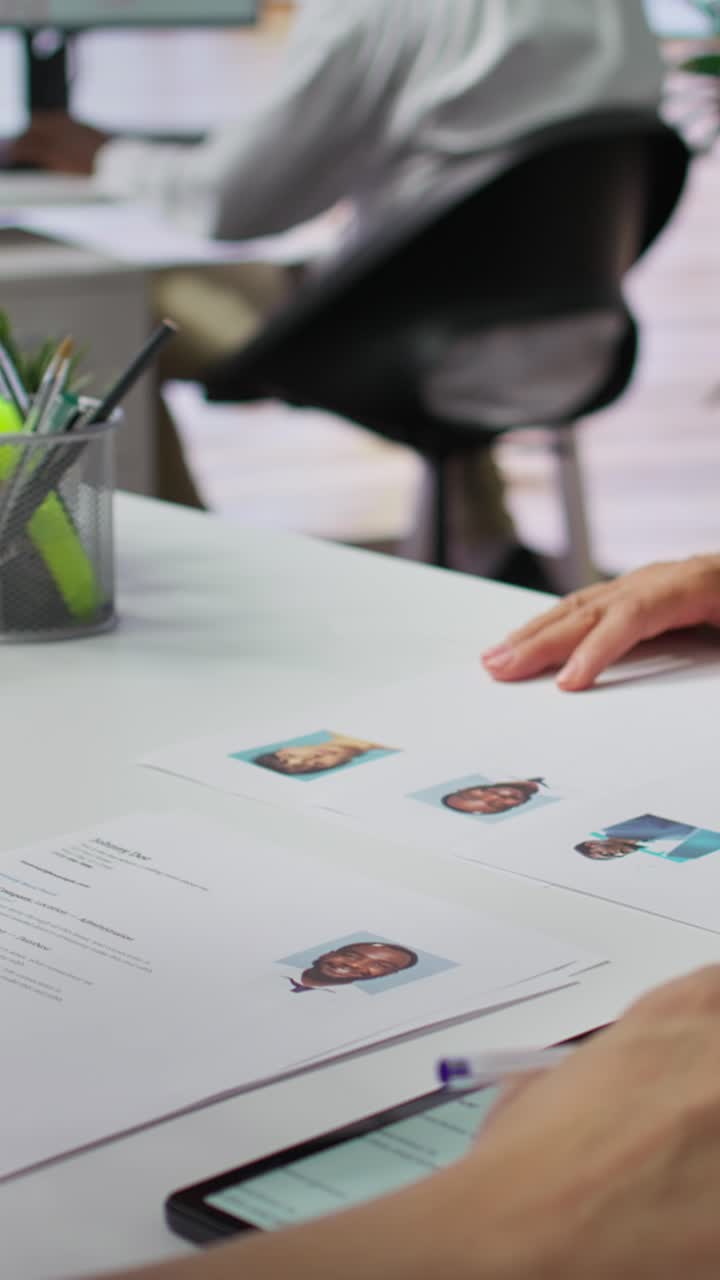 Video verticale: Team di reclutatori che seleziona candidati in base ai loro curriculum.
