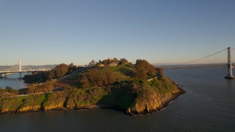 Drone-dolly-out-of-Treasure-Island-and-Bay-Bridge-in-San-Francisco-bay-at-sunset