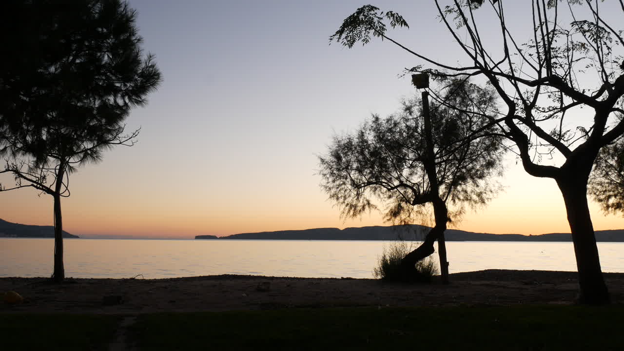 Vista di un molo con i colori del tramonto che si riflettono sull'acqua del mare