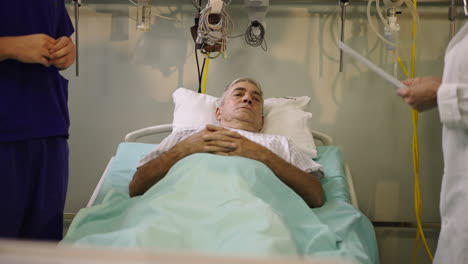 elderly patient in hospital bed with medical staff attending