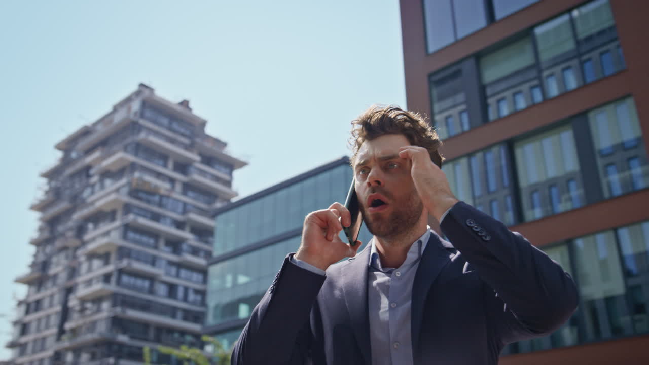 Primo piano di un uomo arrabbiato che litiga al cellulare camminando in centro. Manager che urla al telefono.