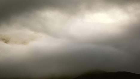 mountain peaks emerging through the clouds at sunrise