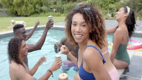 Young-biracial-woman-enjoys-a-pool-party-outdoors